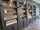 The L'Air retail display wall with dark wood cabinetry and open shelves holding indie and niche fragrances and candles, photographed in a store interior with wood flooring and green walls.